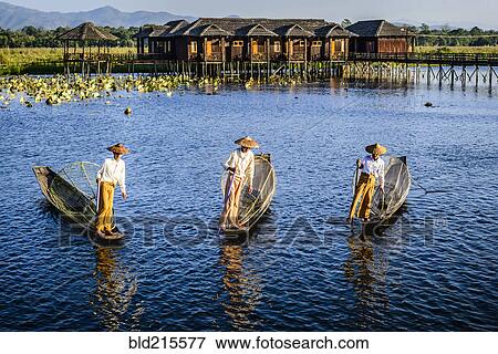Stock Photo - Asian fishermen fishing in canoes on river. Fotosearch
