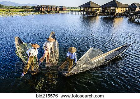 Stock Photograph - Asian fishermen fishing in canoes on river. Fotosearch