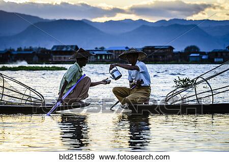 Asian fishermen sharing tea in canoes on river View Large Photo Image Stock Photo - Asian fishermen sharing tea in canoes on river. Fotosearch