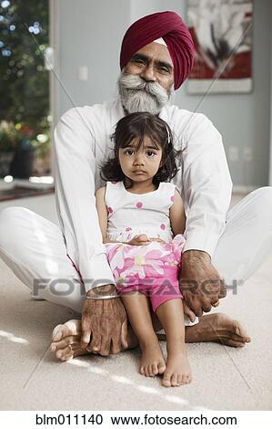 Stock Image - Asian girl sitting in grandfather's lap. Fotosearch