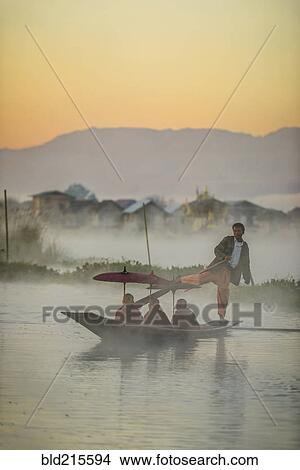 Asian gondolier rowing monks in canoe on river View Large Photo Image Picture - Asian gondolier rowing monks in canoe on river. Fotosearch