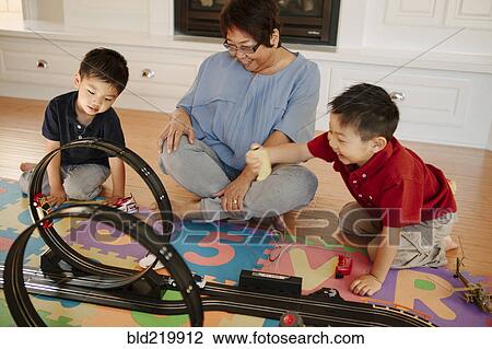 Stock Image - Asian grandmother playing with grandsons. Fotosearch