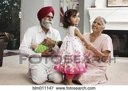 Stock Photo - Asian grandparents in living room with grandchildren. Fotosearch
