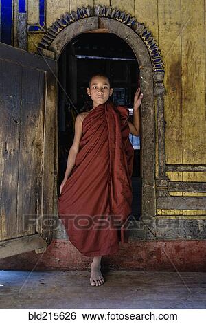 Asian monk-in-training walking out of temple archway View Large Photo Image Stock Photograph - Asian monk-in-training walking out of temple archway. Fotosearch