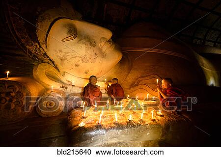 Asian monks-in-training lighting candles at Buddha statue View Large Photo Image Stock Image - Asian monks-in-training lighting candles at Buddha statue. Fotosearch