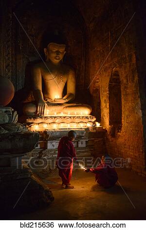 Asian monks-in-training lighting candles at Buddha shrine View Large Photo Image Stock Photograph - Asian monks-in-training lighting candles at Buddha shrine. Fotosearch
