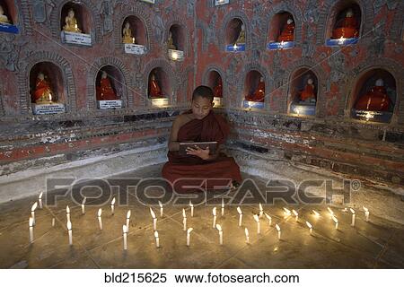 Stock Photography - Asian monks-in-training using digital tablet in ancient temple. Fotosearch