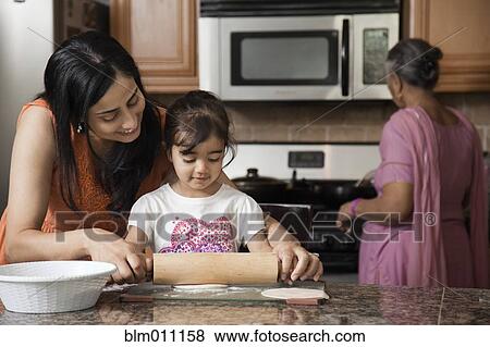 Stock Photo - Asian multi-generation family cooking in kitchen. Fotosearch