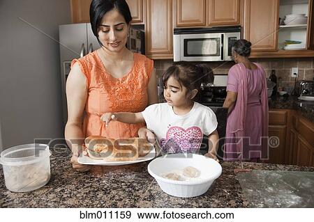 Stock Photo - Asian multi-generation family cooking in kitchen. Fotosearch