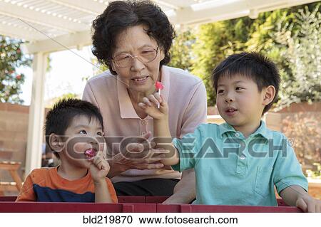 Asian woman and grandsons relaxing in backyard View Large Photo Image Stock Image - Asian woman and grandsons relaxing in backyard. Fotosearch