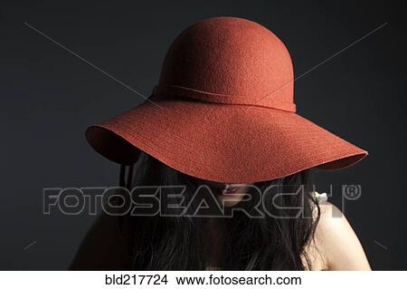 Asian woman hiding behind red hat View Large Photo Image Picture - Asian woman hiding behind red hat. Fotosearch