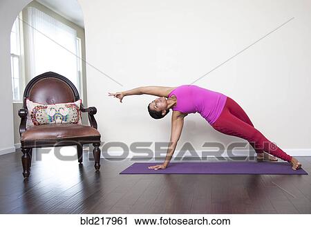 Asian woman practicing yoga in living room View Large Photo Image Stock Image - Asian woman practicing yoga in living room. Fotosearch