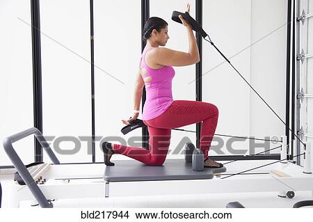 Asian woman using exercise machine in gymnasium View Large Photo Image Picture - Asian woman using exercise machine in gymnasium. Fotosearch