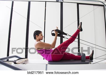 Asian woman using exercise machine in gymnasium View Large Photo Image Stock Image - Asian woman using exercise machine in gymnasium. Fotosearch
