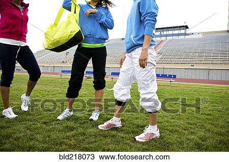 Stock Image - Athletes standing in stadium field. Fotosearch