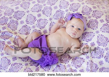 Baby girl wearing purple diaper and headband on blanket View Large Photo Image Stock Image - Baby girl wearing purple diaper and headband on blanket. Fotosearch