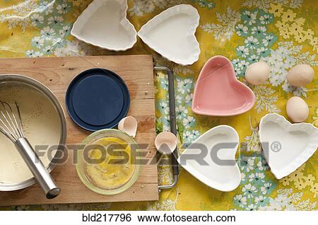 Stock Photograph - Baking tools and heart shape trays on table. Fotosearch