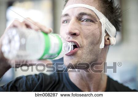 Bandaged man drinking water View Large Photo Image Stock Photo - Bandaged man drinking water. Fotosearch