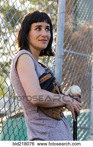 Stock Photograph - Baseball player leaning on fence. Fotosearch