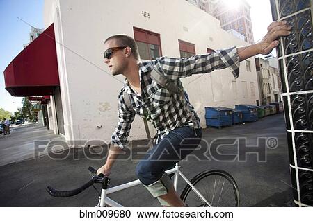 Bicycle messenger stopping on city street View Large Photo Image Stock Image - Bicycle messenger stopping on city street. Fotosearch
