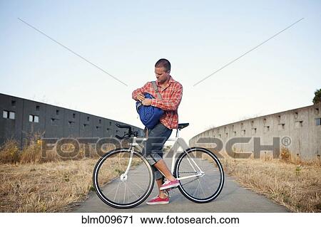 Bicycle messenger stopping on urban path View Large Photo Image Stock Image - Bicycle messenger stopping on urban path. Fotosearch