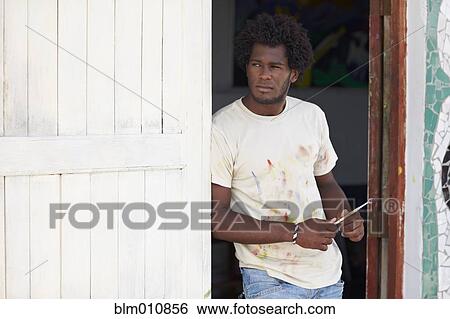 Stock Photograph - Black artist leaning in doorway. Fotosearch