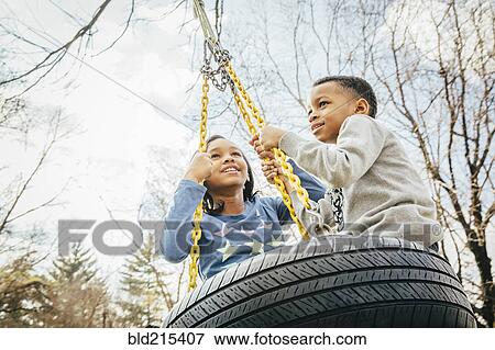 Black brother and sister playing on tire swing View Large Photo Image Stock Photo - Black brother and sister playing on tire swing. Fotosearch
