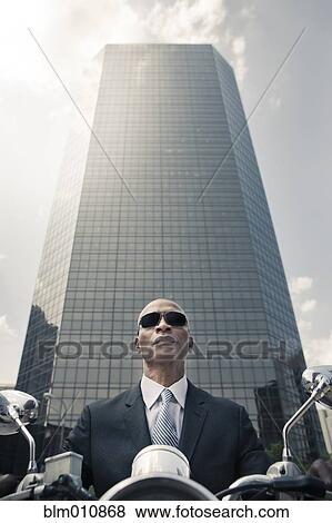 Black businessman riding motorcycle in city View Large Photo Image Stock Photo - Black businessman riding motorcycle in city. Fotosearch