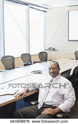 Black businessman sitting in conference room View Large Photo Image Stock Photo - Black businessman sitting in conference room. Fotosearch