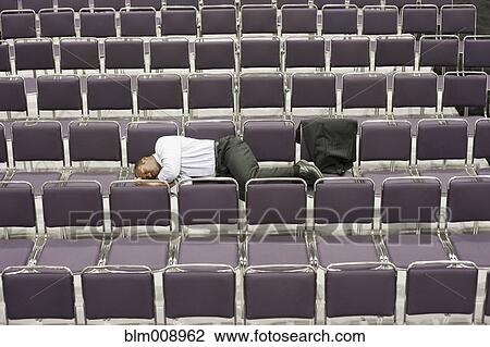 Black businessman sleeping in empty conference center View Large Photo Image Stock Image - Black businessman sleeping in empty conference center. Fotosearch