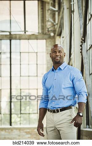 Stock Photo - Black businessman smiling in warehouse. Fotosearch