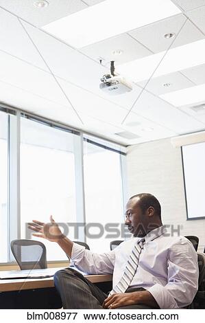Black businessman talking in conference room View Large Photo Image Stock Photo - Black businessman talking in conference room. Fotosearch