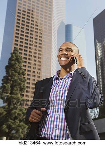 Black businessman talking on cell phone in city View Large Photo Image Picture - Black businessman talking on cell phone in city. Fotosearch
