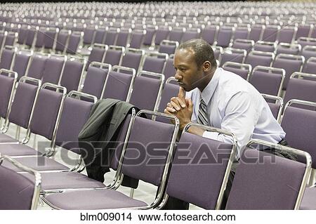 Black businessman waiting in empty conference center View Large Photo Image Picture - Black businessman waiting in empty conference center. Fotosearch