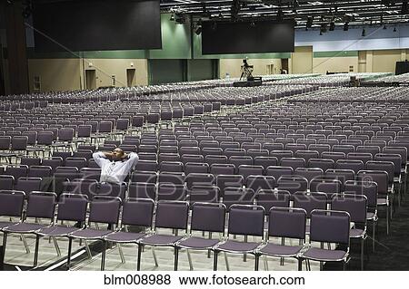 Black businessman waiting in empty conference center View Large Photo Image Stock Photo - Black businessman waiting in empty conference center. Fotosearch