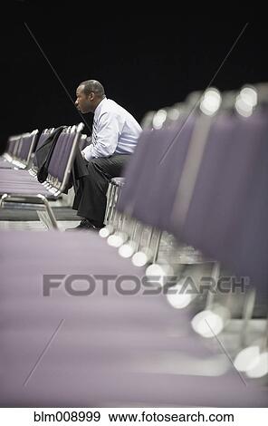 Stock Photo - Black businessman waiting in empty conference center. Fotosearch