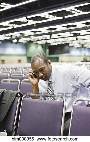 Black businessman waiting in empty conference center View Large Photo Image Stock Photography - Black businessman waiting in empty conference center. Fotosearch