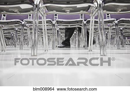 Picture - Black businessman walking in empty conference center. Fotosearch