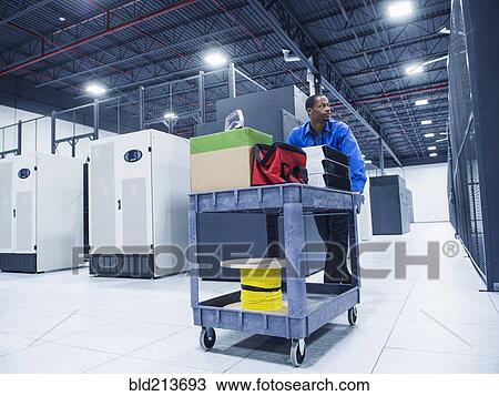 Stock Image - Black businessman working in server room. Fotosearch