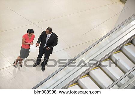 Stock Photo - Black businesspeople talking together in lobby. Fotosearch