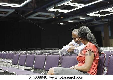 Stock Photograph - Black businesspeople waiting in empty conference room. Fotosearch