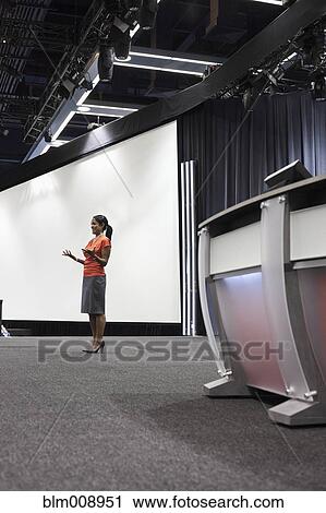 Stock Image - Black businesswoman standing on stage. Fotosearch