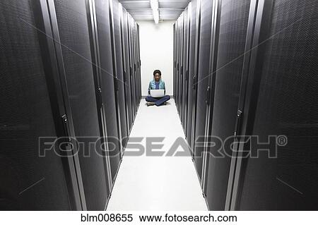 Stock Photography - Black businesswoman typing on laptop in office technology room. Fotosearch