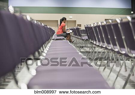Stock Photo - Black businesswoman waiting in empty conference center. Fotosearch
