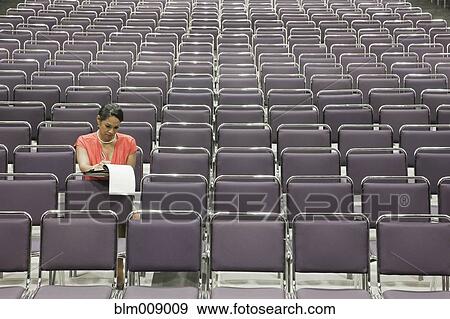 Stock Photo - Black businesswoman waiting in empty conference center. Fotosearch