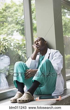 Black doctor resting in lobby View Large Photo Image Stock Image - Black doctor resting in lobby. Fotosearch