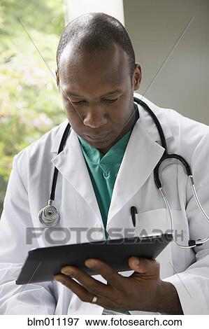 Black doctor using digital tablet View Large Photo Image Stock Photo - Black doctor using digital tablet. Fotosearch