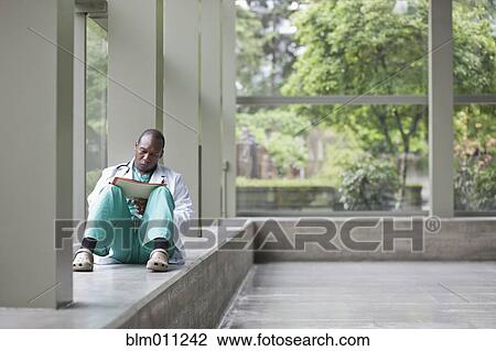 Black doctor working in lobby View Large Photo Image Stock Image - Black doctor working in lobby. Fotosearch