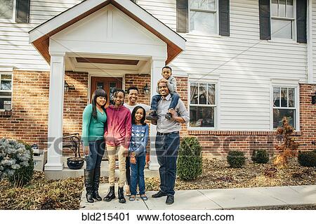 Stock Image - Black family smiling outside house. Fotosearch