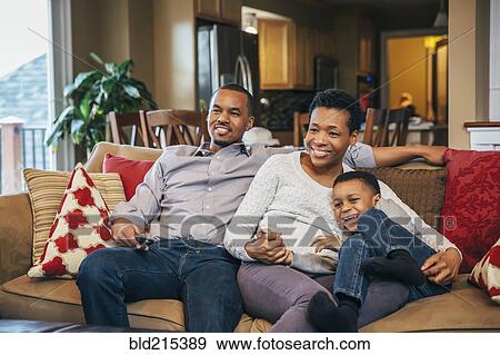 Black family watching television on sofa View Large Photo Image Stock Photo - Black family watching television on sofa. Fotosearch